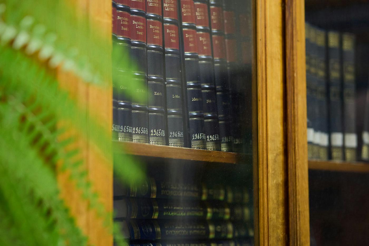 Bound legal volumes behind the glass doors of a wooden library cabinet